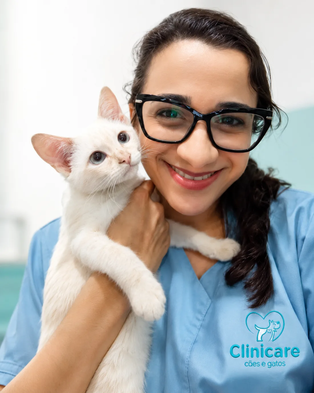 Dra. Bruna Lima sorrindo, com um gato branco no colo